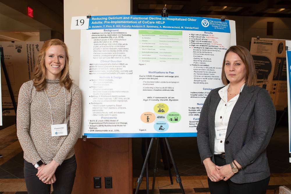Elizabeth Hill (left) and Autumn Baldwin (right) from the Doctor of Nursing Practice program standing in front of their and Thomas Finn's poster.